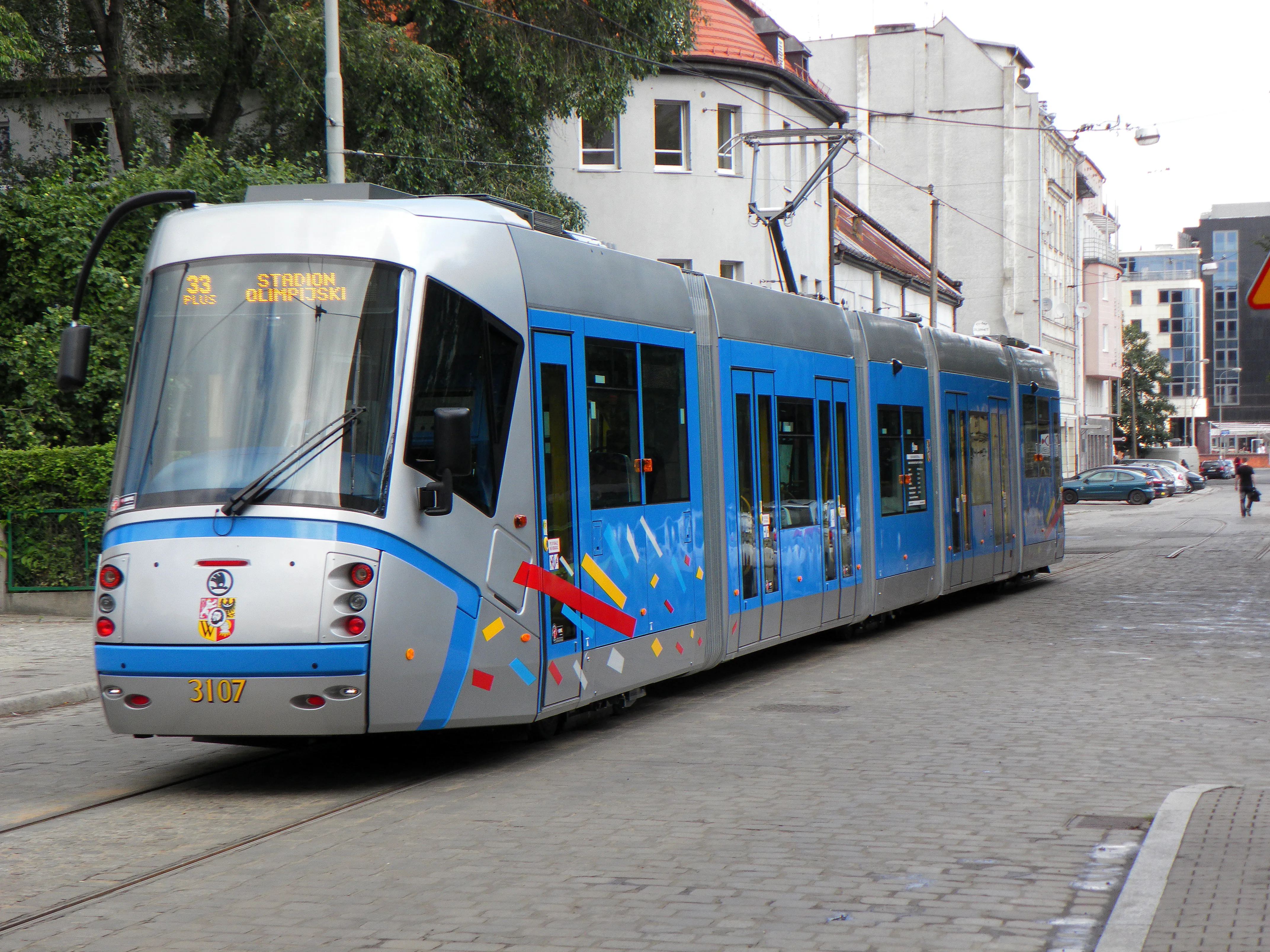 Niebiesko-srebrna Škoda 19T nr 3107 na torze w ul. Wierzbowej, z kolorowym oznakowaniem Tramwaju Plus.